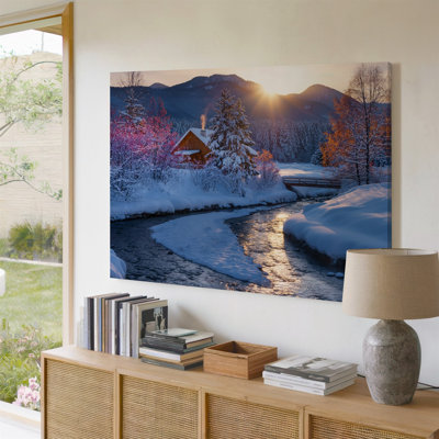 Toile, "Un paysage d'hiver serein au lever du soleil" avec une cabane d'art en bois confortable nichée parmi des arbres recouverts de neige avec une toile rose éclatante