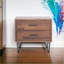 Table basse à finition noyer avec 2 tiroirs, structure en bois peu encombrante pour le salon
