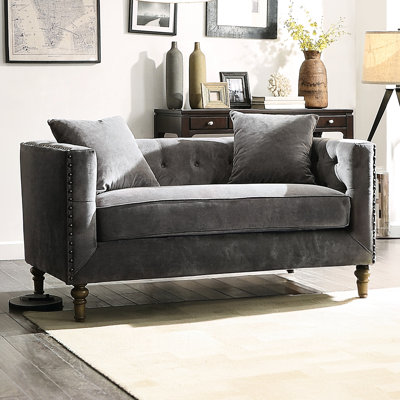 Velours gris avec coussins inclus, détails des boutons sur le dos et les accoudoirs, garniture cloutée, rembourrage en mousse de plumes pour abri haut, assise de 23 po de profondeur, profondeur de produit de 34 po, bois tourné