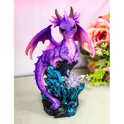 Figurine fantaisiste adorable dragon mauve perché sur une grotte en cristal à DEL