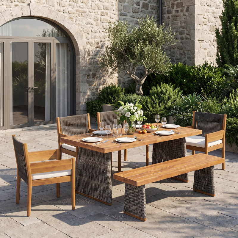 Ensemble de salle à manger d'extérieur Celia 6 places en bois d'acacia de style bohème, comprenant une table à lattes, un banc à pieds en résine tressée et des fauteuils en corde tressée.