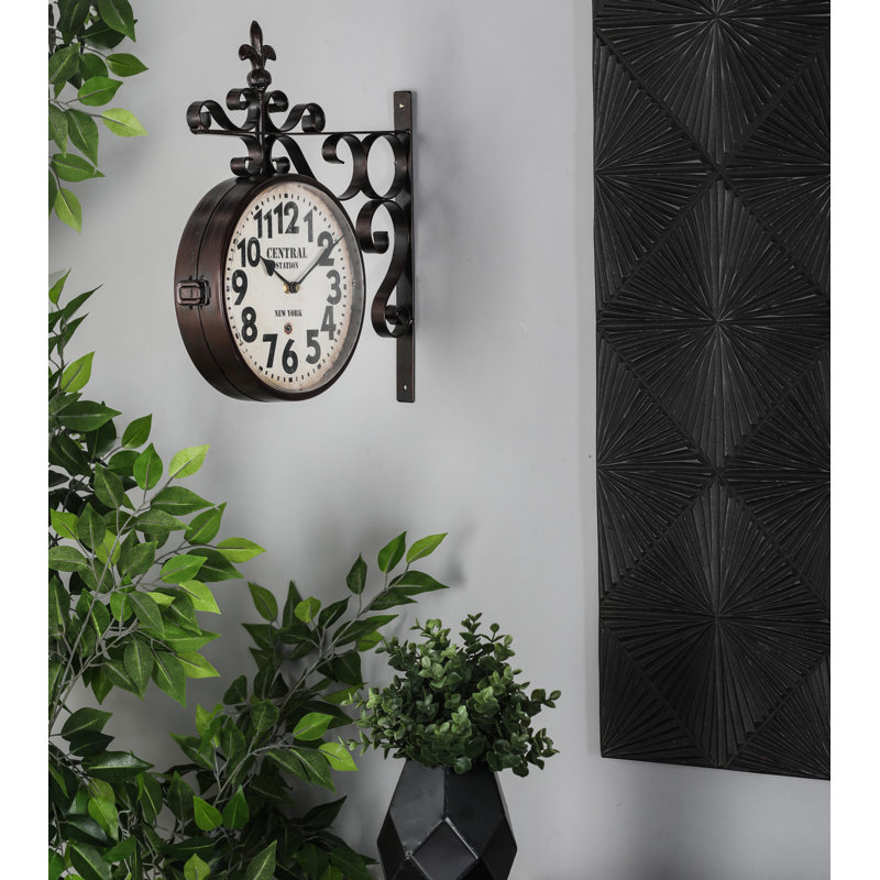 Horloge décorative à double face à fixation murale en métal noir avec volutes et faîteau avec une fleur de lys rétro de 15 po x 3 po x 16 po Richarson