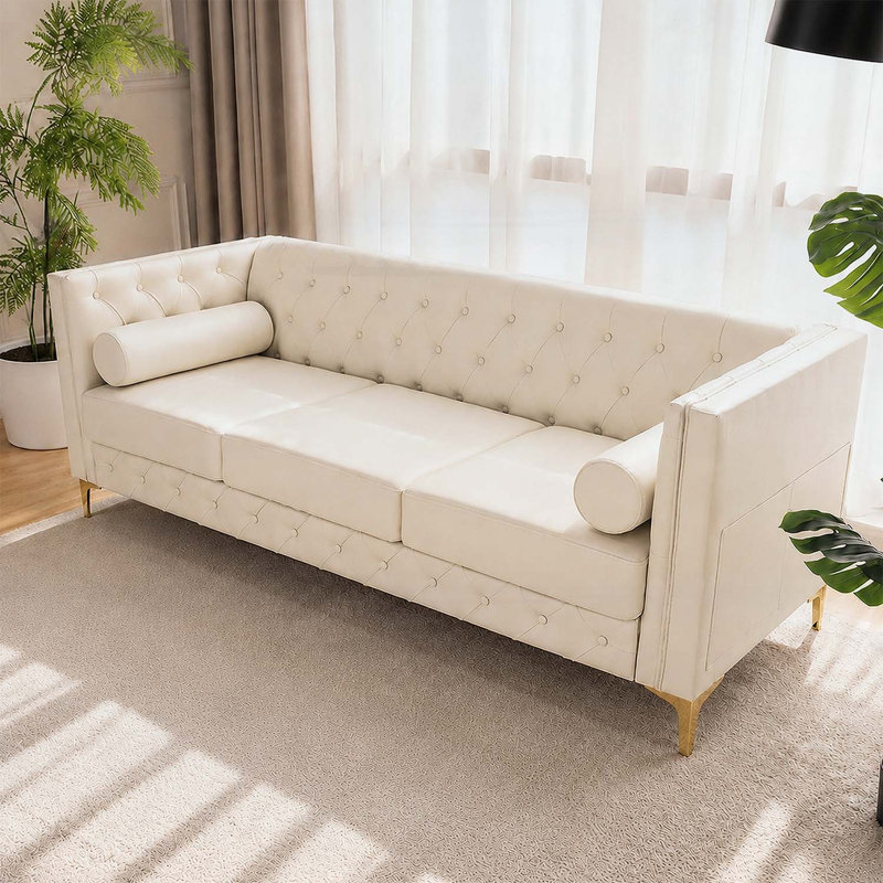 Canapé 3 places de luxe en similicuir blanc crème avec capitonnage à boutons et pieds en métal doré, parfait pour les espaces de vie modernes