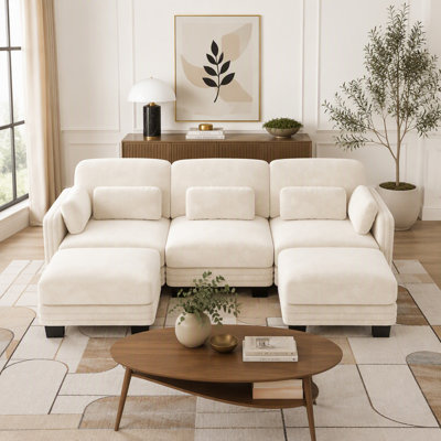 Canapé d'angle modulaire 3 places au design moderne et minimaliste capitonné, avec 2 poufs amovibles et des coussins d'assise épais et confortables.
