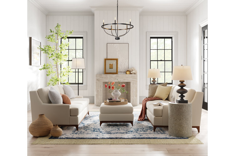 White living room with a beige sofa set, a beige upholstered coffee table, and marble fireplace.