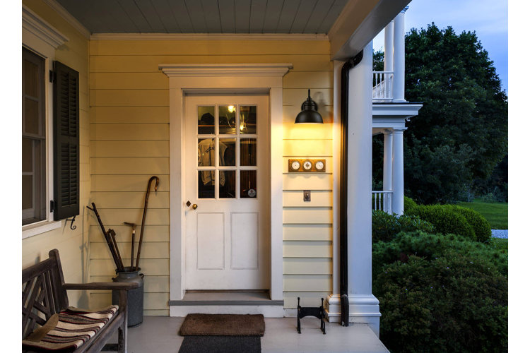 a front porch with a black dusk-to-dawn light next to the front door