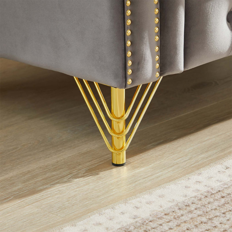 Luxueux canapé Chesterfield en velours avec des clous en cuivre, des boutons capitonnés et des pieds en métal, parfait pour une assise élégante et confortable
