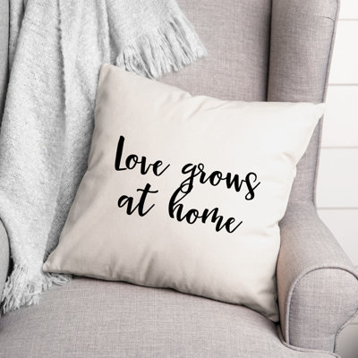 Coussin décoratif noir et blanc "Love Grows at Home"