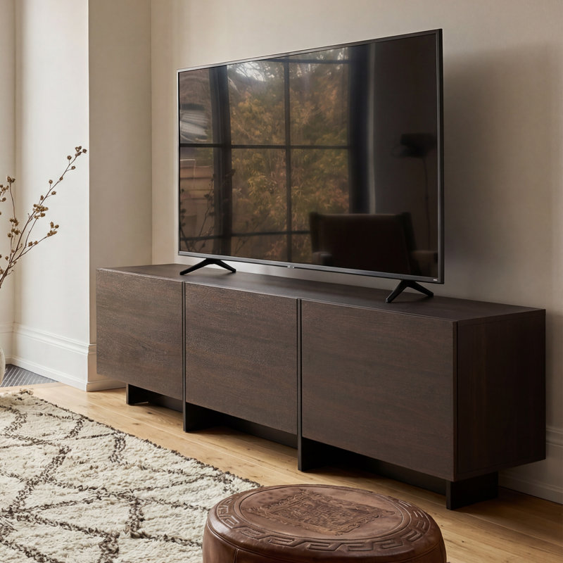 Meuble télé discret de 182 cm de large pour téléviseurs jusqu'à 224 cm, avec 3 placards rabattables et un socle surélevé.