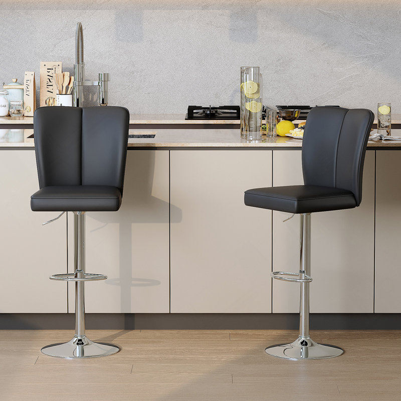 Ensemble de tabourets de bar modernes en polyuréthane noir - 2 pièces, avec des dossiers verticaux et lisses avec des pieds en métal argenté en forme de trompette. Idéal pour les bars, les salons, les salons et autres espaces similaires.