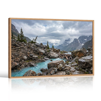 Tableau sur toile représentant une rivière turquoise avec des rochers gris et des pins
