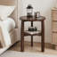 Une table d'appoint ronde en bois massif à double couche avec rangement compartimenté. Convient à une utilisation comme table d'appoint, table de chevet ou objet décoratif dans les salons, les chambres à coucher ou les petits appartements.