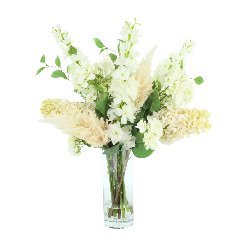 Arrangement assorti d'hortensias et de delphiniums dans un vase en verre