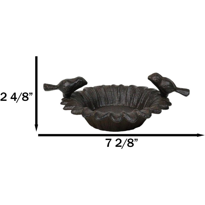 Petits tourtereaux rustiques en fonte perchés sur un bain de jardin