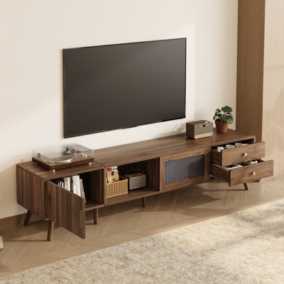 Meuble télé de 76 po en bois veiné pour téléviseurs de 85 pouces, avec portes vitrées ondulées, rangement dissimulé et pieds robustes de couleur naturelle.