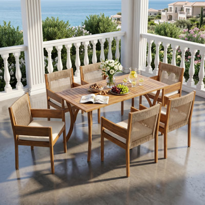 Ensemble de salle à manger d'extérieur Celia pour 6 personnes, style côtier moderne, en bois d'acacia, avec chaises à accoudoirs tressés, coussins et table à lattes à pieds incurvés.