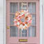 Couronne de jour de l'Action de grâce avec citrouille blanche suspendue à la porte et fenêtre décorative