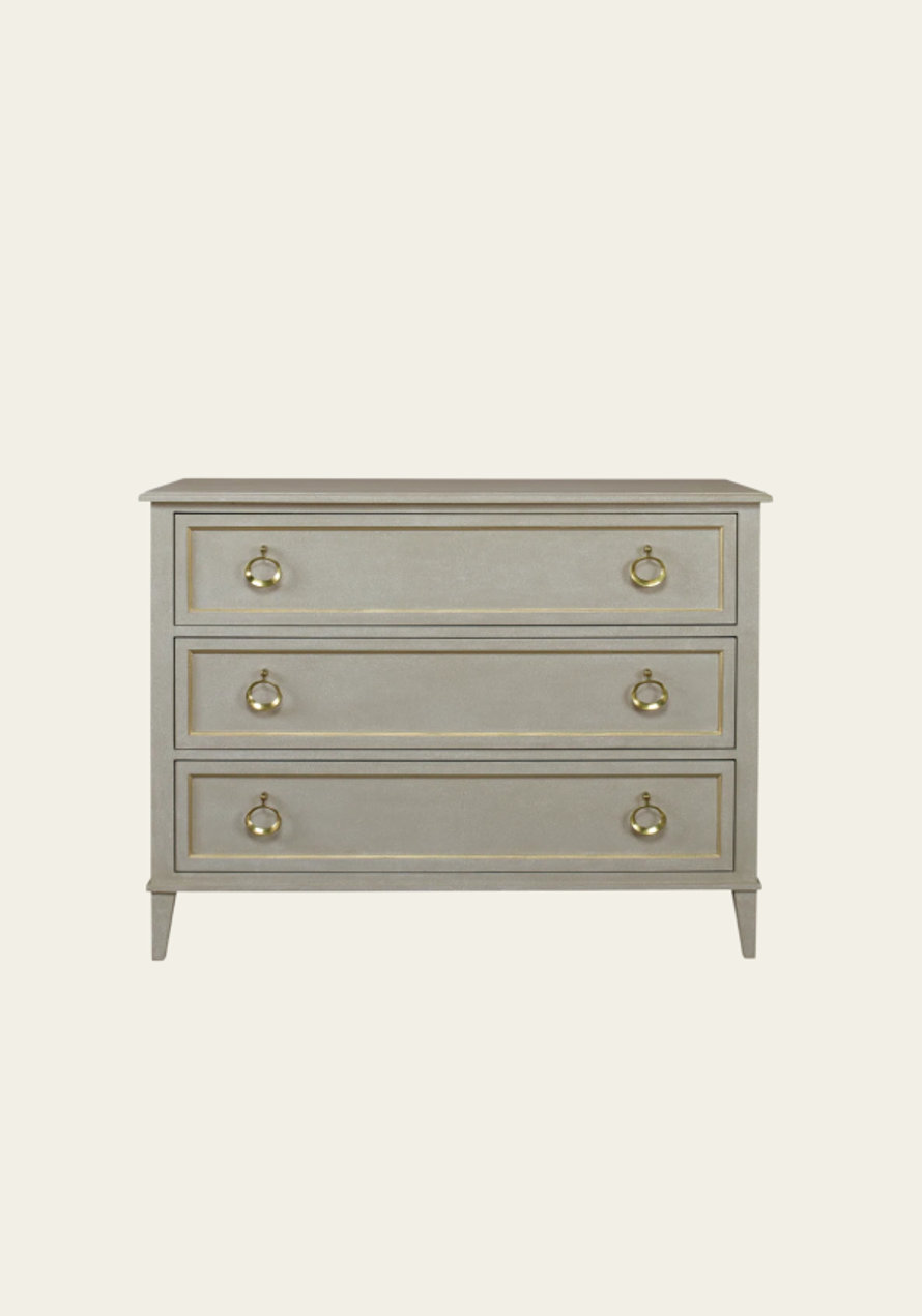 A chest of drawers in gray with gold accents.