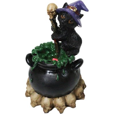 Figurine de sorcière chapeau noir de sorcière dans un chaudron à DEL avec crânes