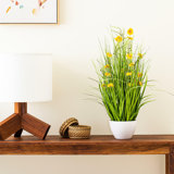 Cosmos jaune artificiel en pot et herbe verte.