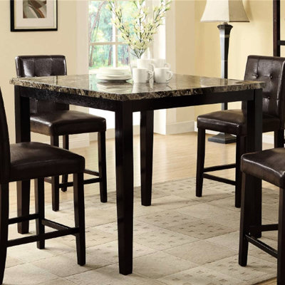 Table de salle à manger avec plateau en faux marbre brun foncé et placage en bouleau, style contemporain.