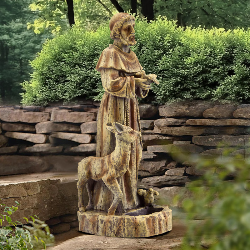 Statue de jardin religieuse représentant saint François, le protecteur de la nature avec mangeoire à oiseaux