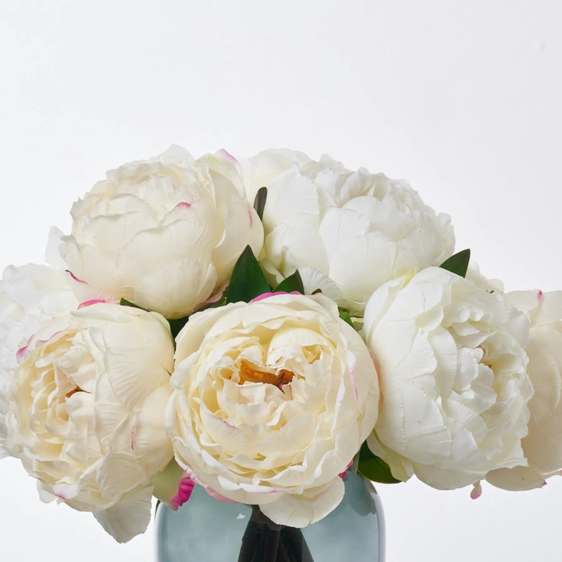 Pleine illusion de pivoines blanches et crème dans un vase en verre fumé