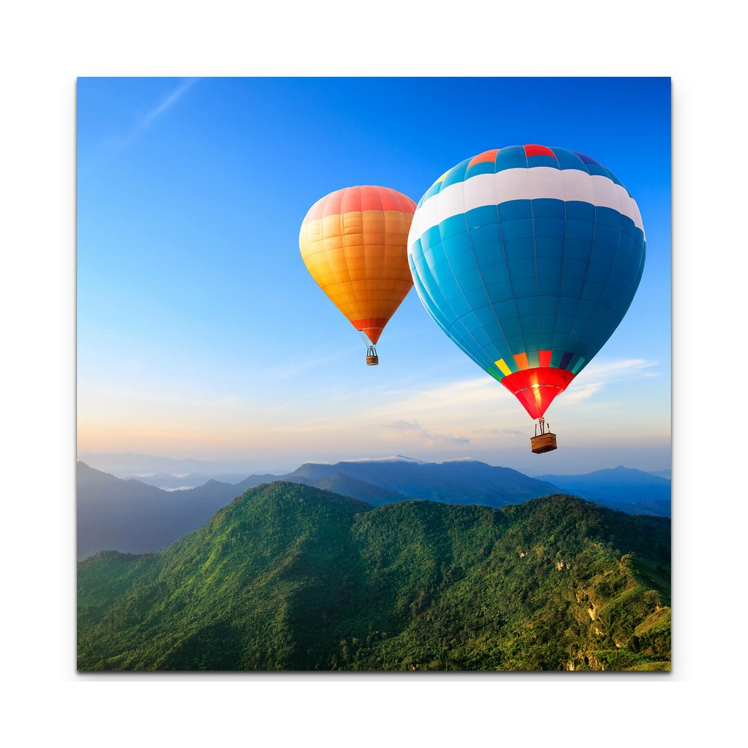 Leinwandbild Bunte Heißluftballons über Bergkette