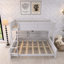 Lit simple superposé au-dessus de grand lit blanc avec armoires de rangement et ports USB-804523629