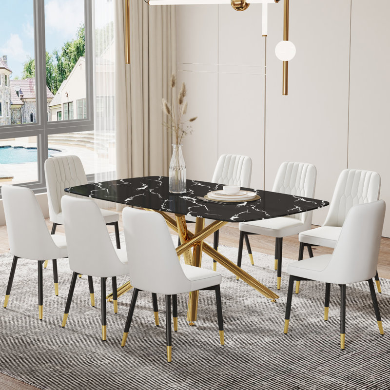 Ensemble de table et de chaises. Grande table de salle à manger rectangulaire minimaliste moderne avec plateau en verre noir imitation marbre 0,39 et pieds en métal doré, jumelée à 8 chaises en polyuréthane blanc avec pieds en métal noir.