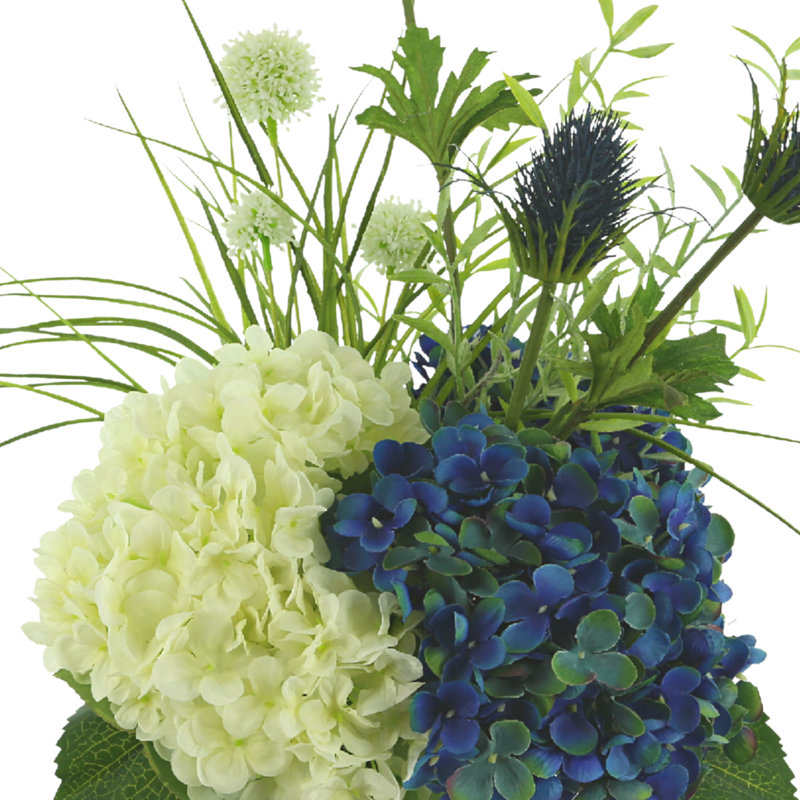 Hortensia et chardon Holland dans un vase en verre