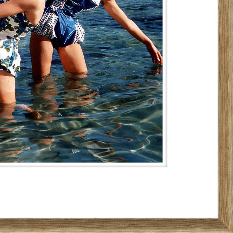 «Trois femmes heureuses et un homme jouant dans l'eau» par Getty Images - cadre photographique sur papier