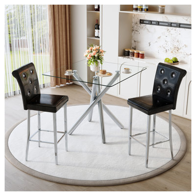 Ensemble de table de bar moderne avec dessus en verre et 2 tabourets de bar à hauteur fixe, style pub contemporain, avec piètement en métal chromé et sièges en similicuir noir, idéal pour un îlot de cuisine ou un bar à domicile.