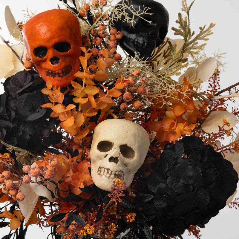 Décoration de tête de mort d'Halloween chic avec eucalyptus orange, hortensia noir et arrangement de baies orange