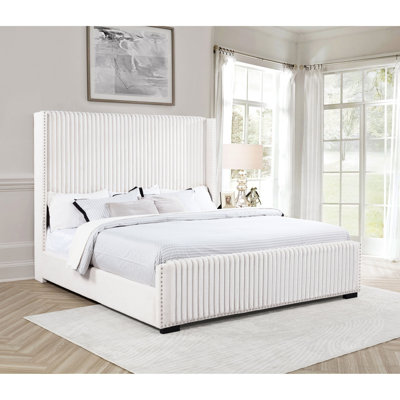 Très grand lit tapissier moderne à oreilles crème avec capitonnage vertical, pieds carrés et profil bas pour chambre à coucher