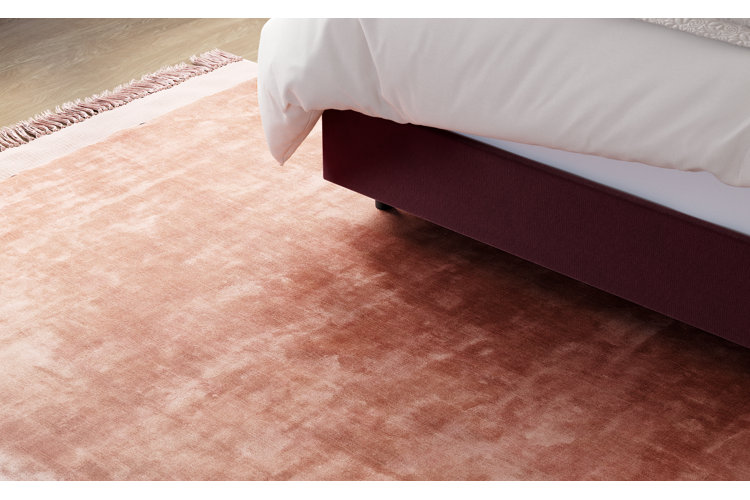 dark pink rug beneath a bed