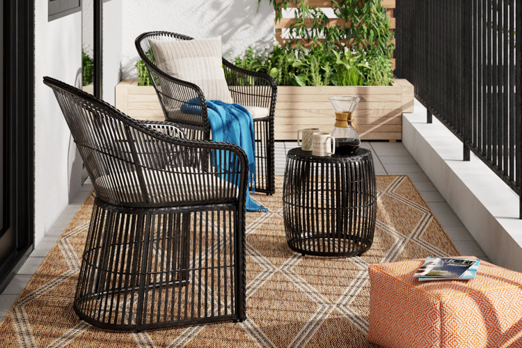 balcony with two wicker chairs, matching side table, and a jute area rug