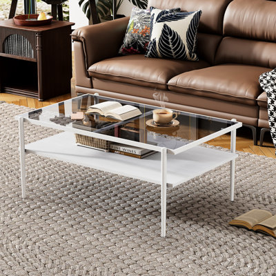 Table basse grise en verre trempé avec pieds blancs, ajoutant du charme au salon rectangulaire et à une décoration intérieure élégante