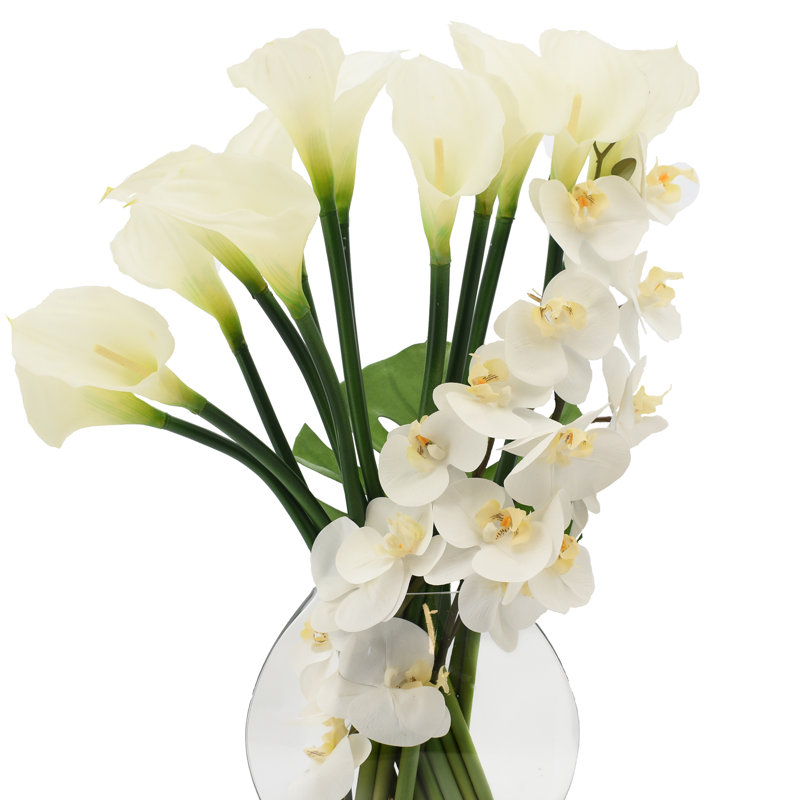 Orchids, Calla Lily And Philodendron Leaves Arranged In A Clear Circular Glass Vase
