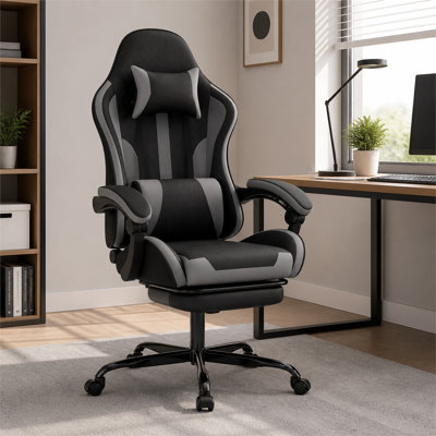 Black and gray ergonomic gaming computer chair, height adjustable and 360-degree swivel, equipped with footrest, lumbar support, and headrest, suitable for both office work and gaming.
