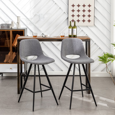 Tabouret gris à hauteur de comptoir (2 pièces). Revêtement confortable. Pieds en métal. Repose-pieds intégré pour plus de confort. 15 po. Dossier de 28,25 po. Assise de 2. Pieds confortables avec finition noire. Repose-pieds. 17,5 po