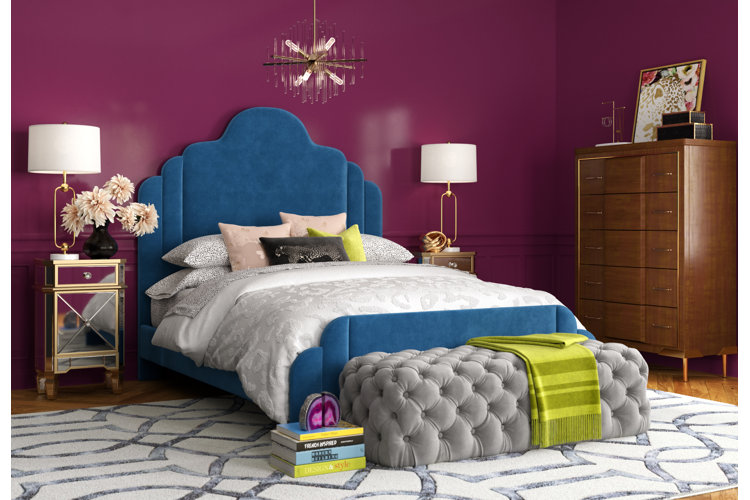 magenta bedroom with a navy velvet bed gray tufted bedroom bench, and two gold mirrored nightstands