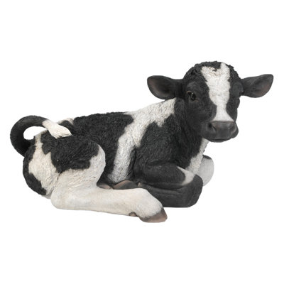 Statue brune et blanche couchée sur une vache