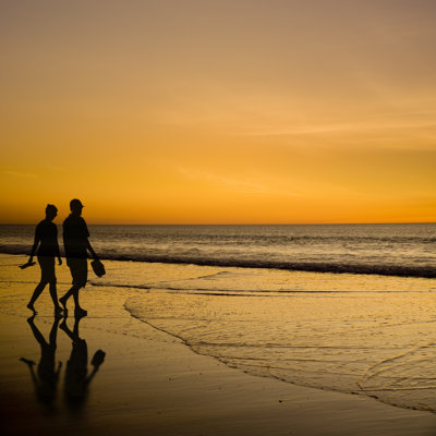 Young Couple On Beach by Travellinglight - Wrapped Canvas Print