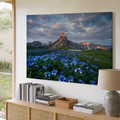 Toile, "Un vaste paysage montagneux s'étire sur un fond dominé par un art mural"