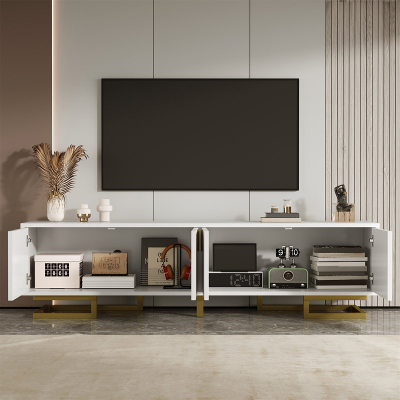 Meuble télé moderne avec portes d'armoire texturées, poignées décoratives et pieds de support robustes.