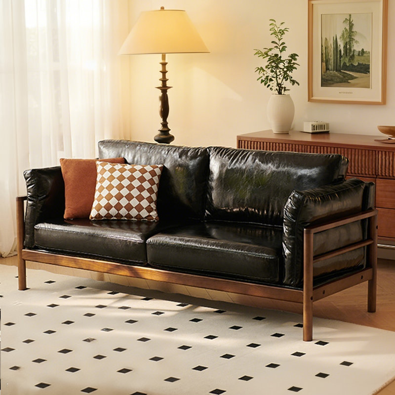 Un canapé double en cuir noir avec coussins, H 32,68 po x l 66,93 po x P 32,68 po