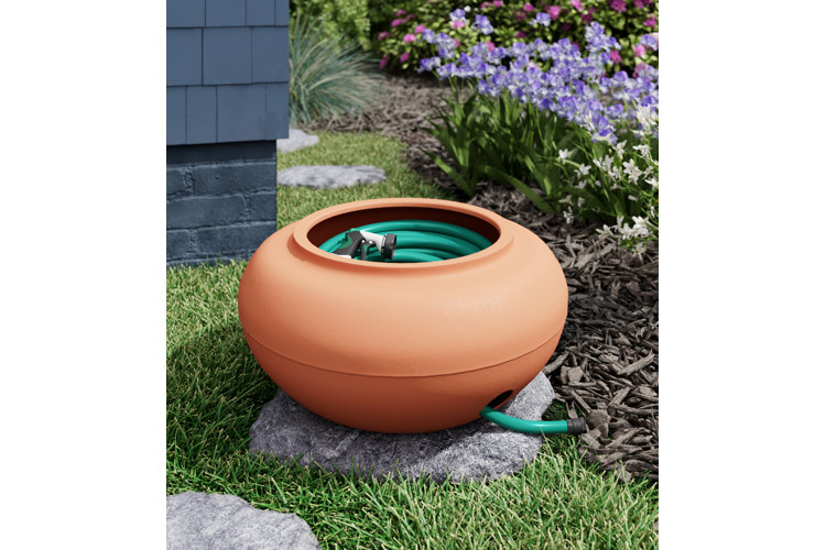 terracotta garden hose holder on a paving stone
