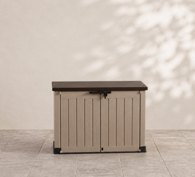 Beige outdoor garden storage box with a dark brown lid and double doors on a tiled patio.