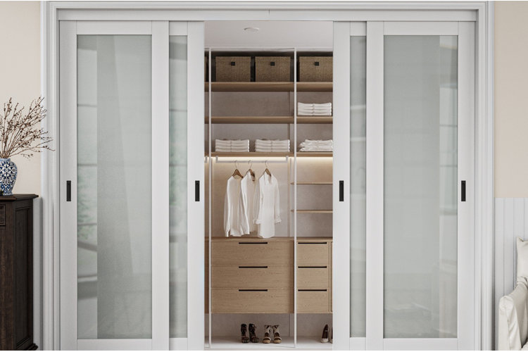 sliding white closet doors with frosted panels partially opened to show an organized built-in closet